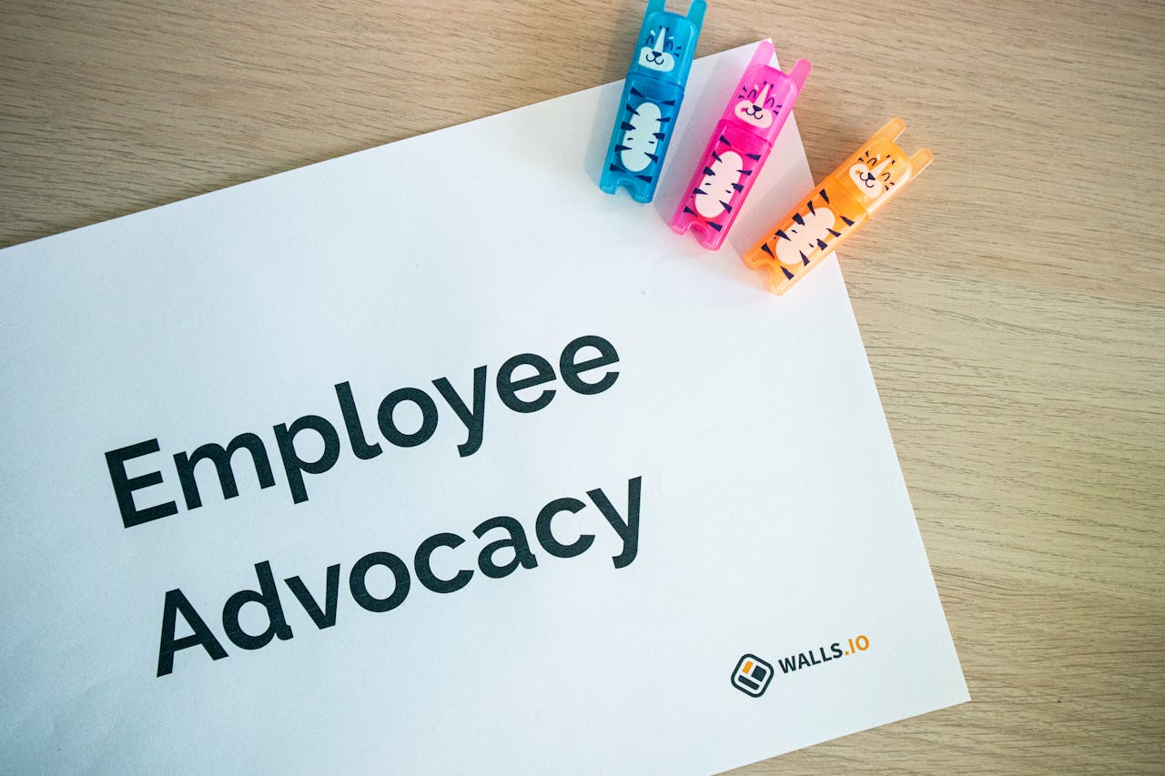 Colorful office stationery featuring quirky clips and Employee Advocacy sign on a desk.